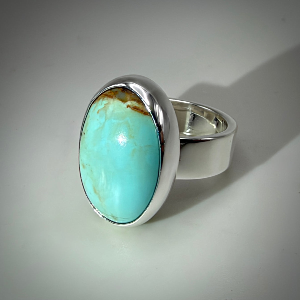 Blue oval turquoise ring shiny silver with gray background 