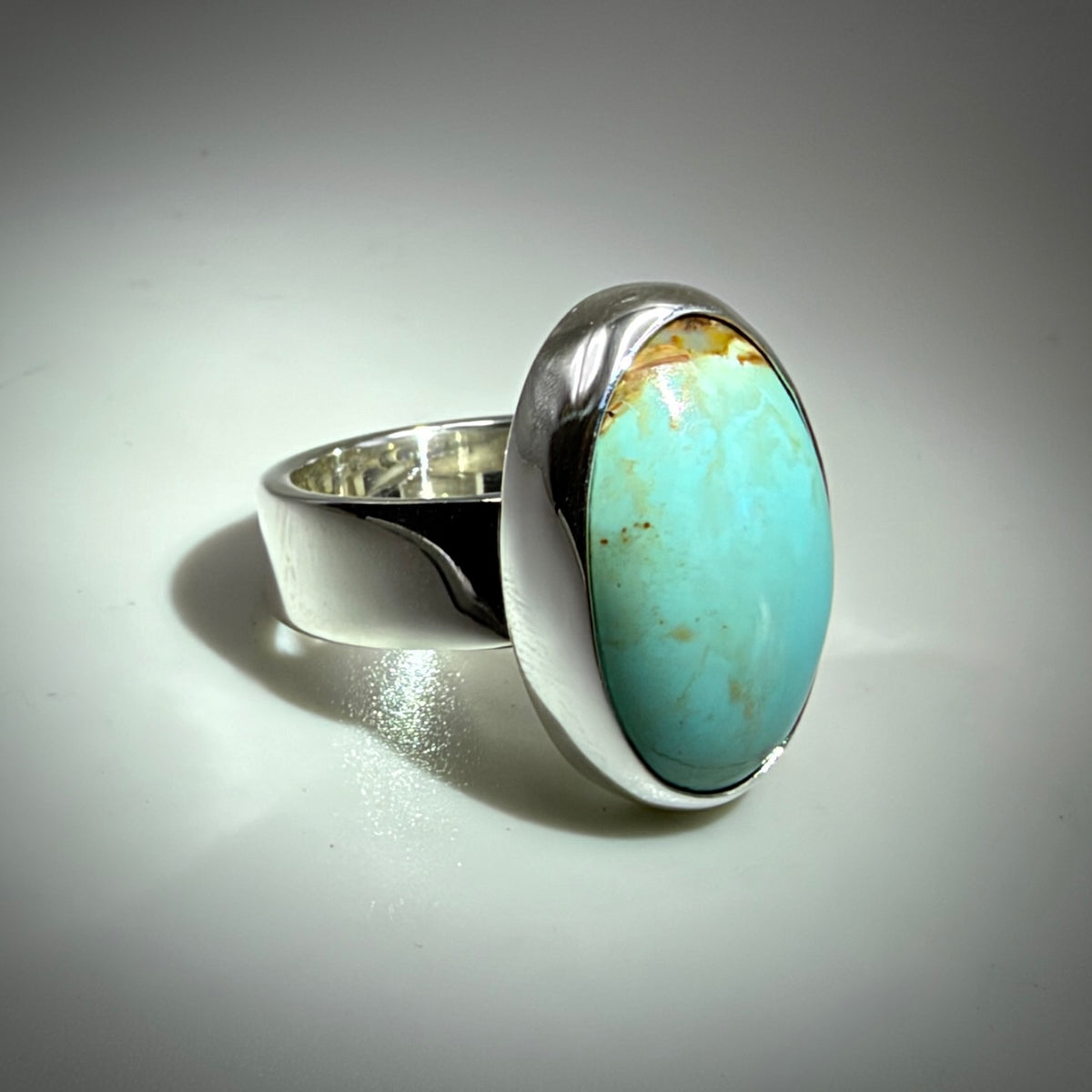 Blue oval turquoise ring shiny silver with gray background 